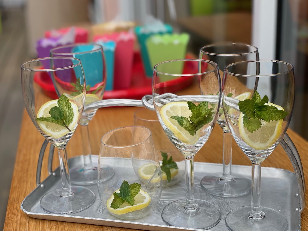 Glasses with lemon slices and mint are ready to be filled with lemonade.