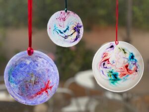 Homemade suncatchers hanging in a window.