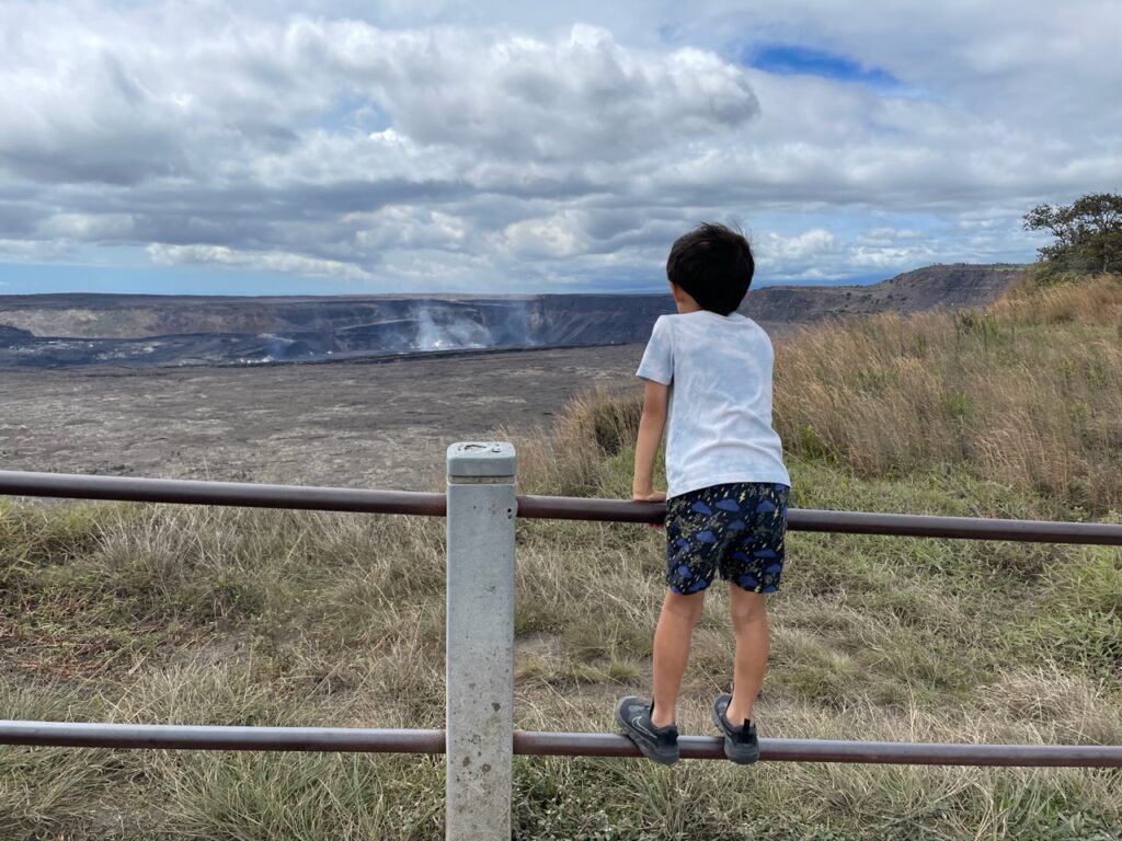 Child looks at steaming Halema’uma’u crater.
