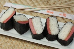 Spam Musubi is made with a slice of seasoned Spam and a layer of rice, wrapped around nori (dried seaweed sheets).