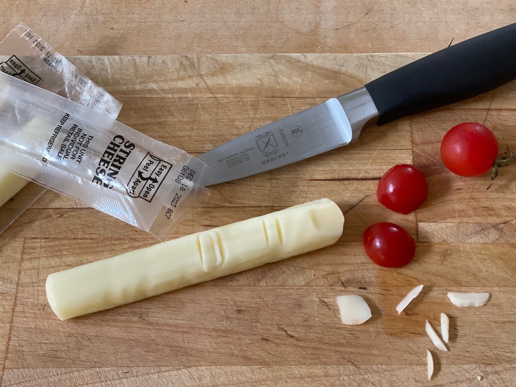 Carve out a space for the nail bed and make notches on the string cheese for the finger and knuckles.