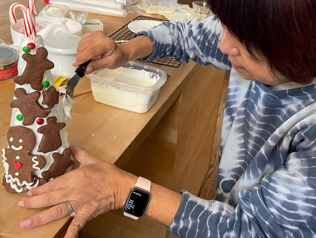 Use icing to frost the plastic-wrap-covered Styrofoam Christmas tree, then attach cookies and M&Ms.