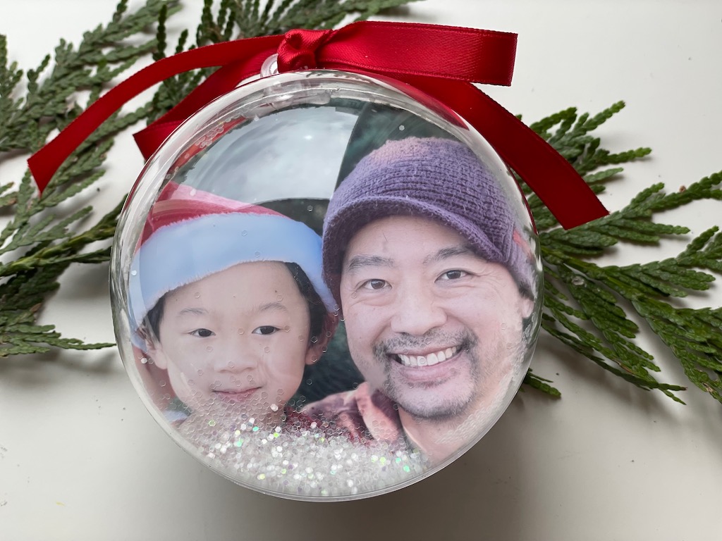 Photo Christmas ornaments are made with bath bomb shells. Glitter snow adds a snow globe effect.