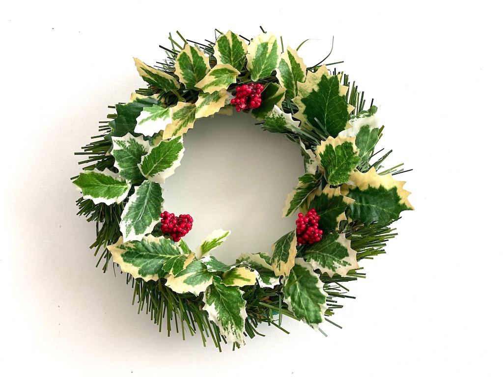 Artificial greens are hot-glued to a styrofoam wreath base to make this 6-inch DIY Christmas wreath.