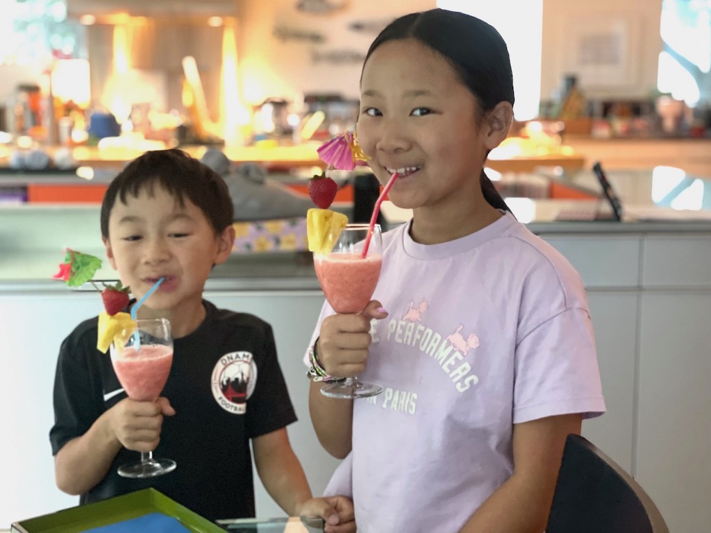 Kids enjoy their umbrella drinks, made by pureeing strawberries with pineapple juice and adding ice cubes to thicken into slush. 