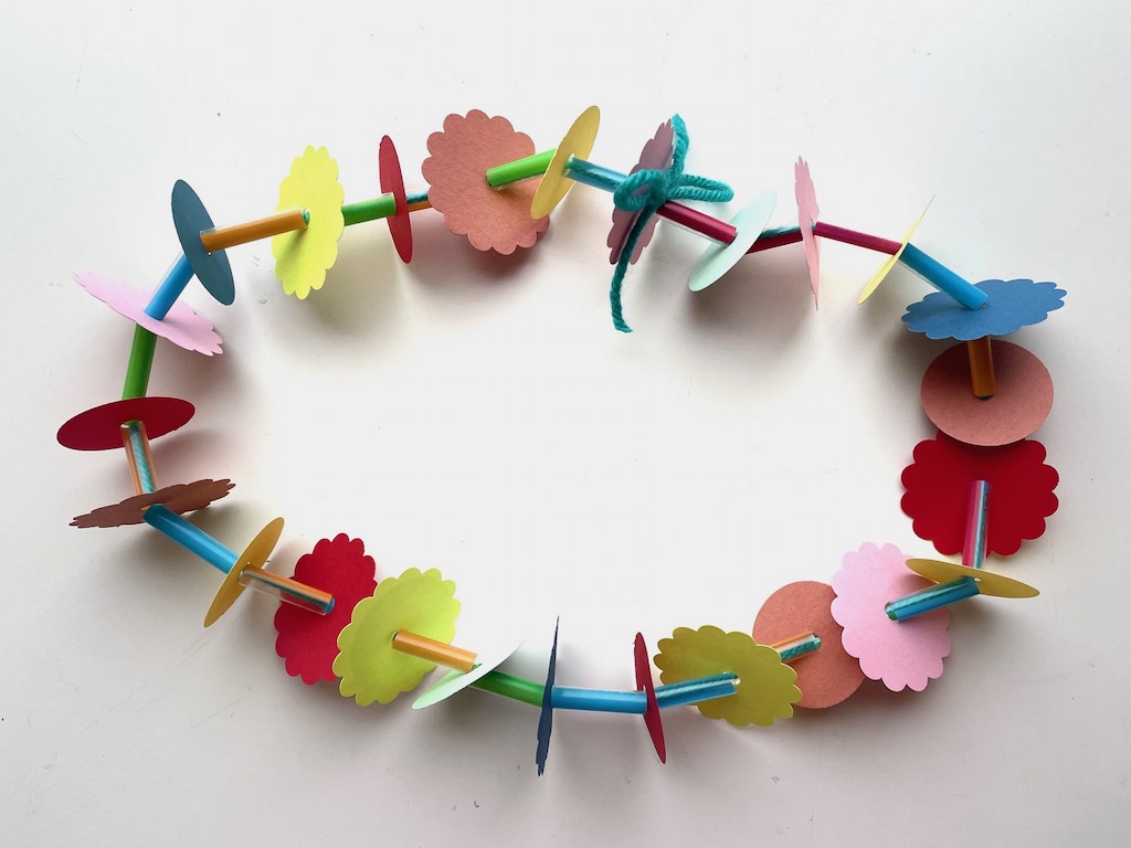 A simple kids activity: use construction paper, straws, and yarn to make a lei.