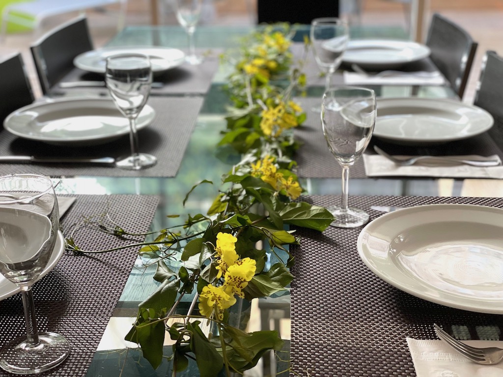Dress your table for the luau party. This table features a table runner of real vines interspersed with artificial orchids and uses woven brown placemats.
