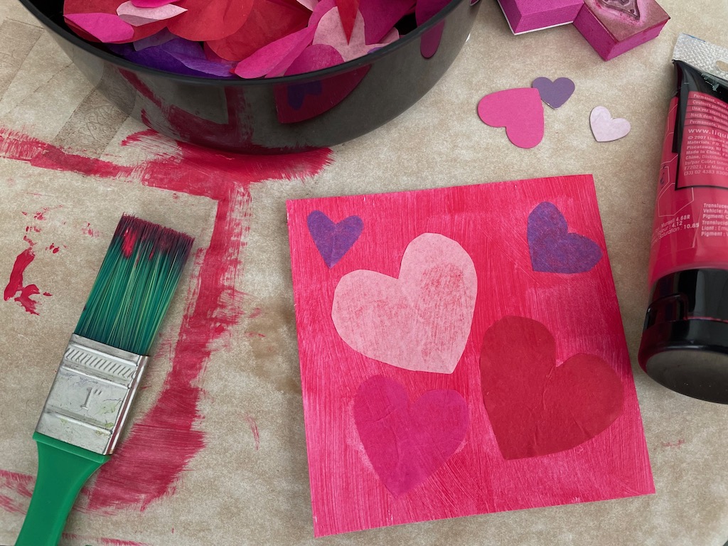 The first step in making these valentines: paint the background and lay down the tissue paper hearts while paint is wet; they will adhere without glue.
