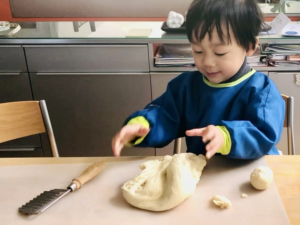 Three-year-old child is given a batch of bread dough to play with, like Play-Doh.