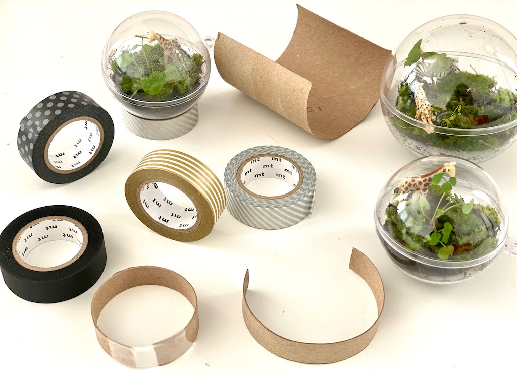 To make a stand for a terrarium, make a collar from toilet paper roll strips and cover with washi tape.