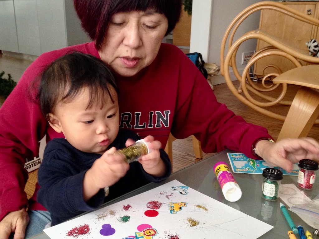 Toddler with grandma working on an art project together.