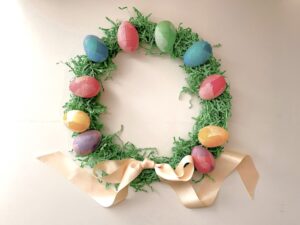 Plastic easter eggs are covered in tissue paper, then wired into a wreath covered in Easter grass.