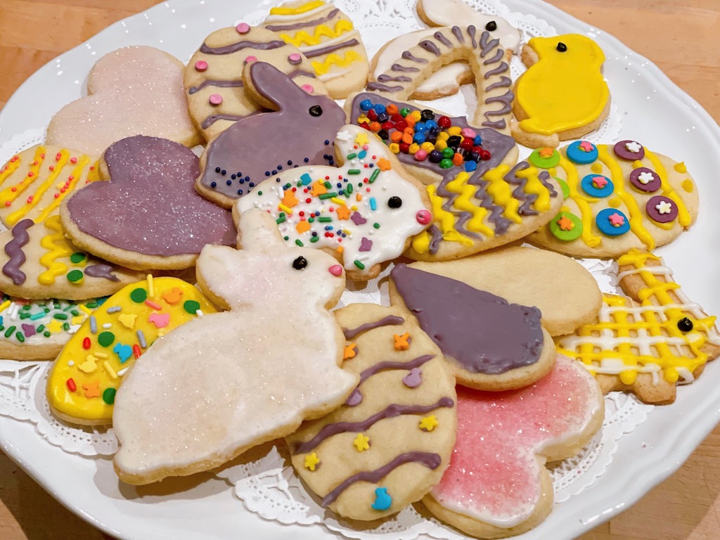 Plateful of decorated Easter cookies with bunnies, chicks, and eggs.