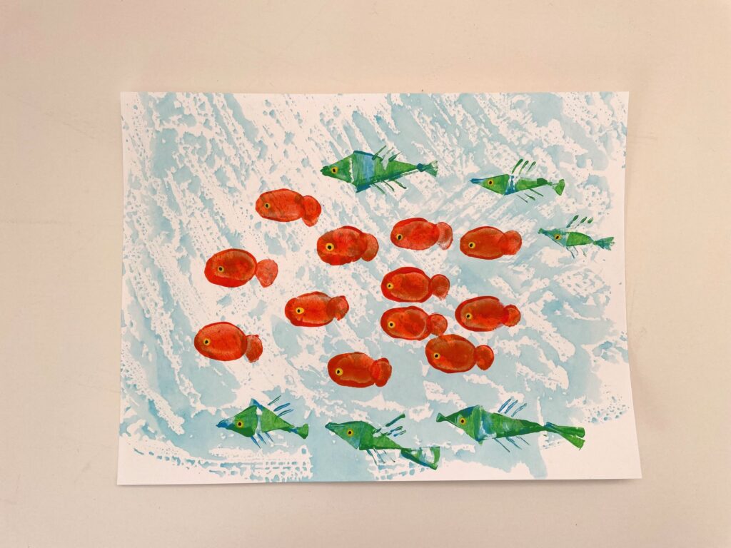 This under-the-sea scene features fish made with fingerprints and another type of fish made by spreading paint with cardboard.