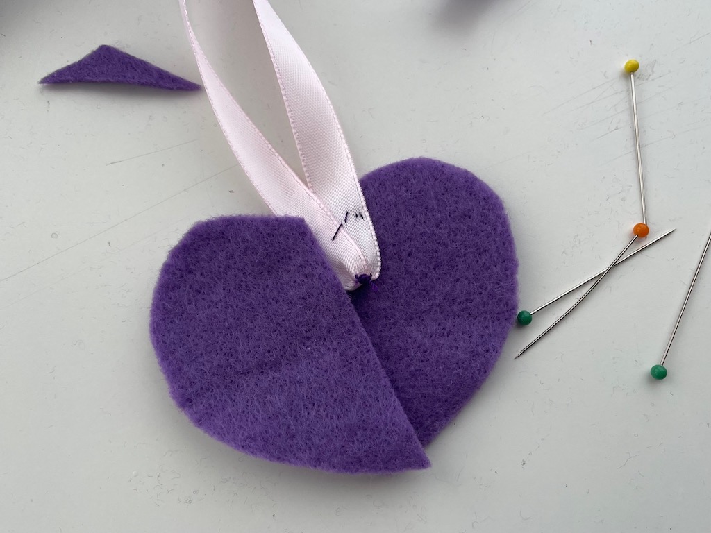 Fold ribbon in half and gather the center before pinning it to the heart.