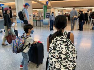 Family at airport with backpacks.