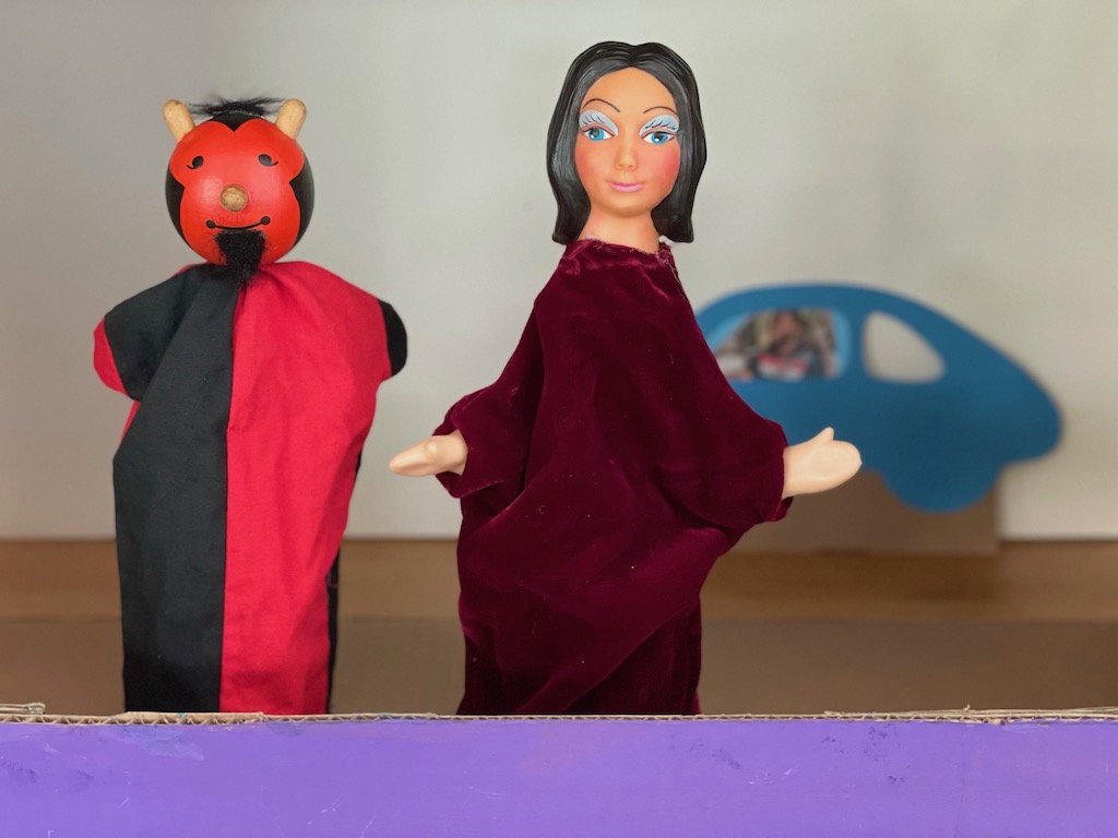 Three of the puppet characters in the play: the kidnapper, the queen, and the man driving a car.