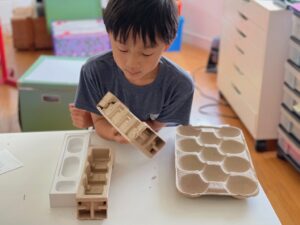 Child examines throwaway items for creative inspiration.