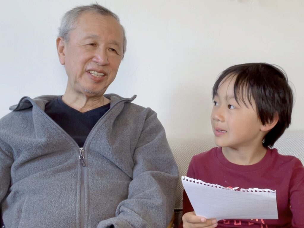 Child interviews grandpa for a family history lesson.