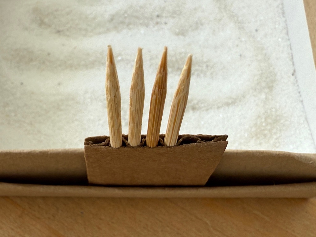 Toothpicks inserted into corrugated cardboard show the basis for the construction of the rake.