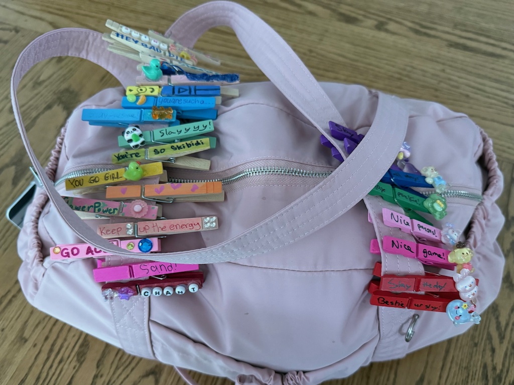 The handles of Miss T's gym bag are loaded with clothespin clips featuring messages of affirmation clipped randomly and anonymously, from strangers.