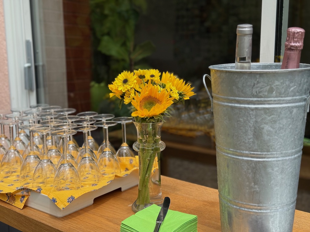 Inexpensive wine glasses sit ready for guests. Wines chill in a French flower bucket filled with ice.