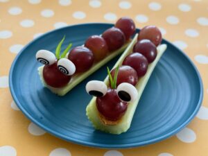 Caterpillars are made with grapes on celery sticks, held in place with peanut butter; antennae are slivers of green onion.