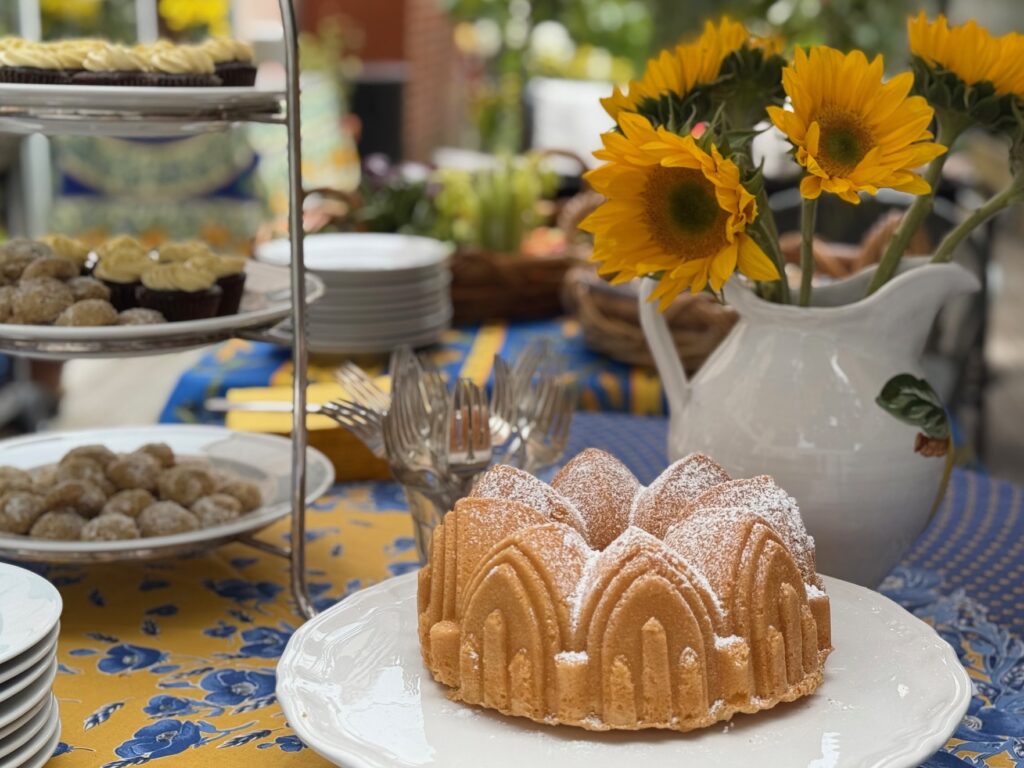 A pound cake, mini cupcakes, and walnut tea cookies are some of the easy party food made for a garden party. Sunflowers and a French provencial tablecloth set the mood.