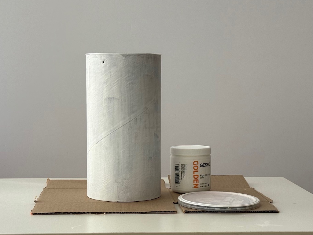 Oatmeal container is primed with gesso, ready for painting.