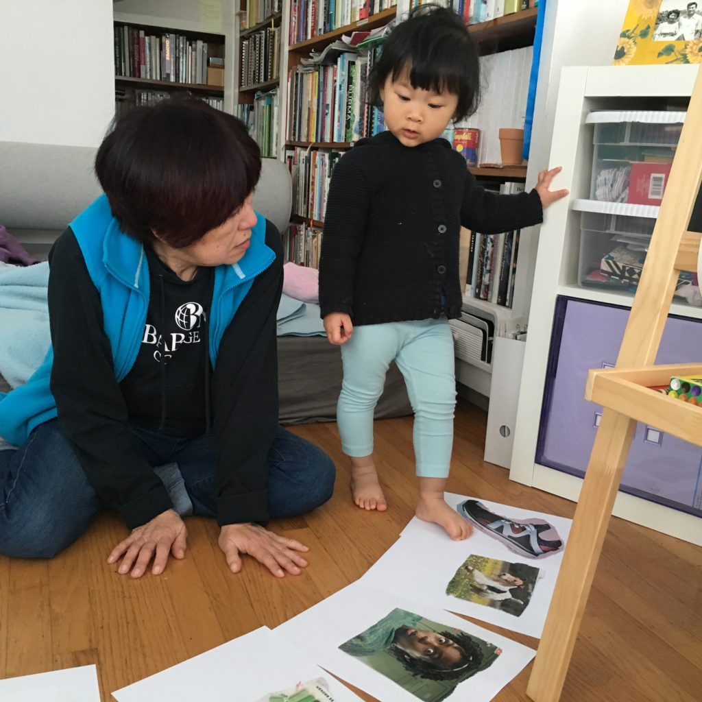 Grandma and grandchild review magazine images. The grandchild is challenged to use the images to tell a story.