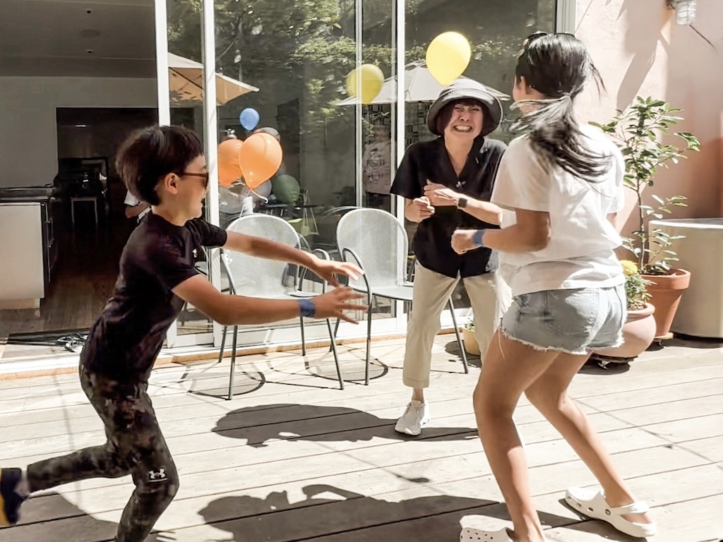Grandma and grandkids playing the game, Lemonade, try to avoid being tagged.