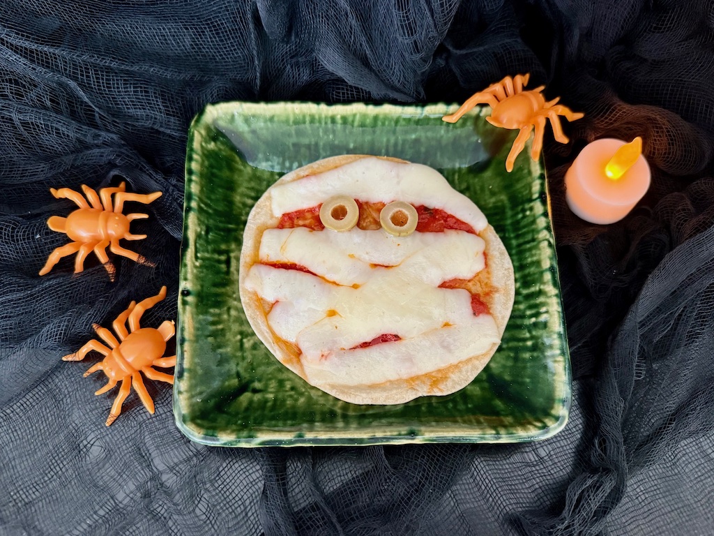 Mummy pizzas are made from mini flour tortillas topped with pizza sauce and cheese strips to create the mummy wrappings. Add pimento-stuffed olive slices for the eyes.