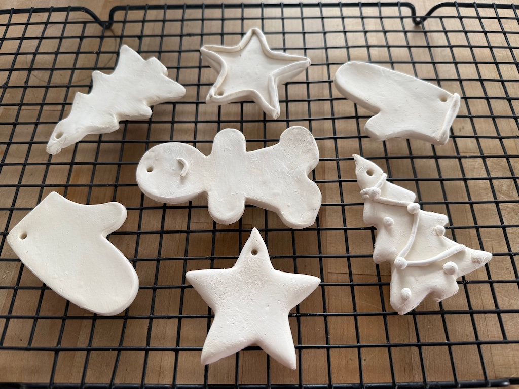 Air dry Christmas cookies are set on a rack. Keep parchment under the cookies until they are partially firm, then remove the parchment and dry directly on the rack.