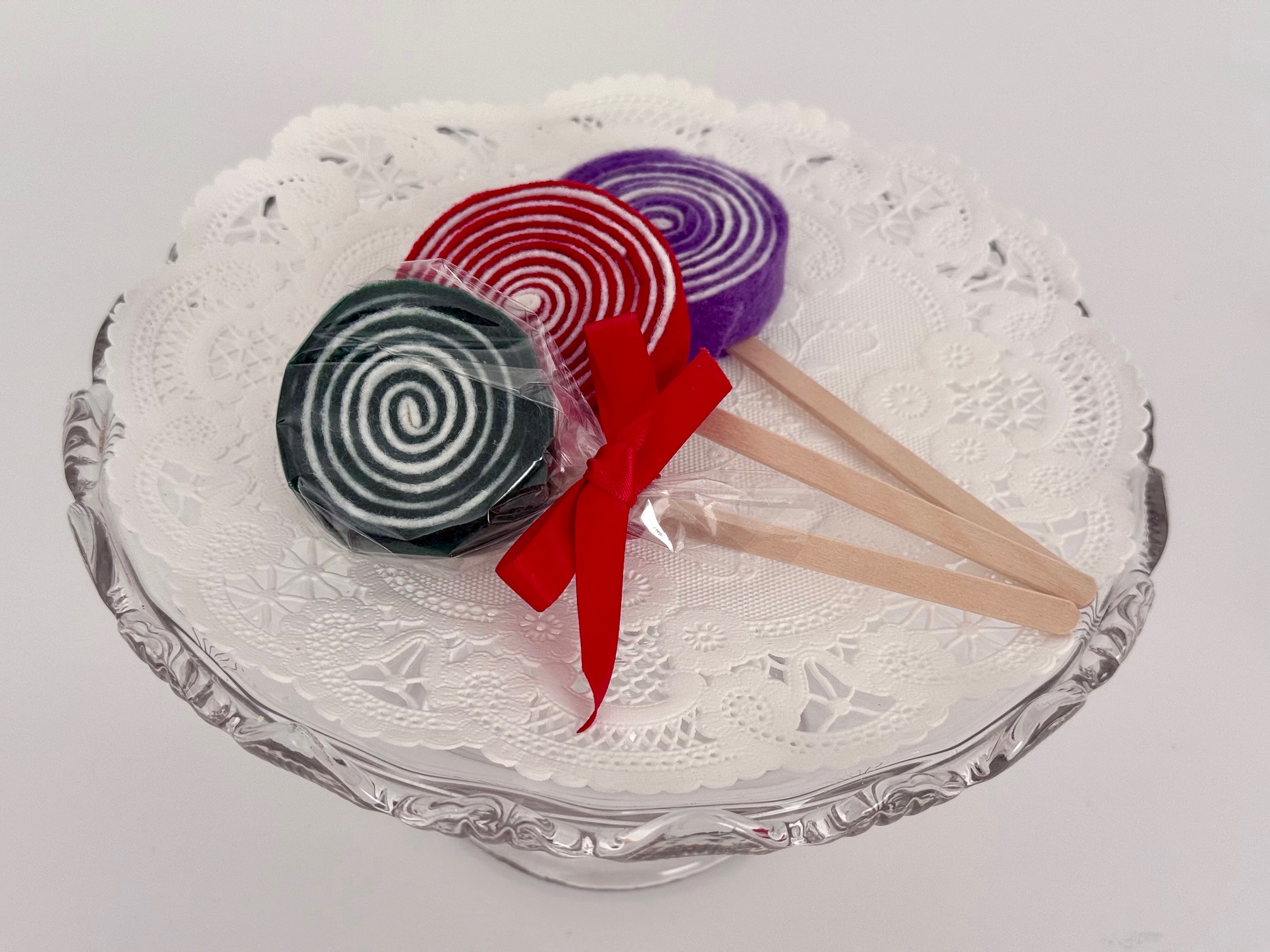 Lollipops are made from felt strips rolled into a circle with a coffee stirrer stick glued to the back.