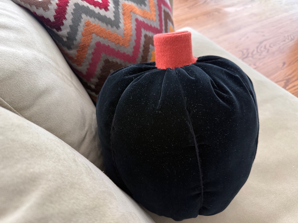 Make a simple pumpkin pillow with fabric, yarn, and felt.