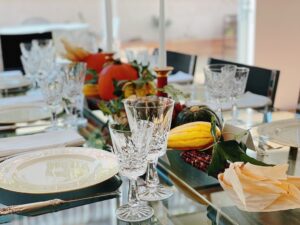 Thanksgiving table centerpiece is made with a row of fall produce and icy intertwined.