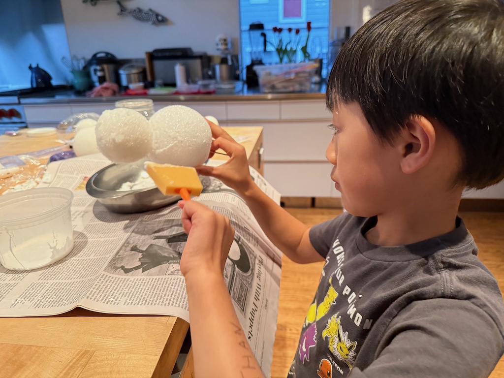 Child uses foam brush to brush on glue; then he'll sprinkle epsom salts over the glue.