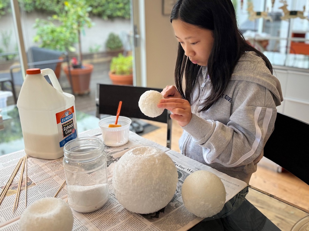 Child prepares to assemble snowman head to the body.