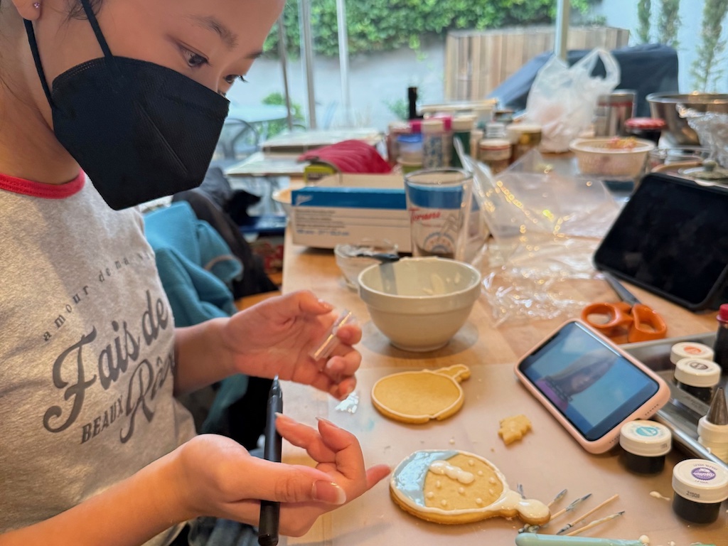 Child decorate a Christmas cookie. This year, we decorated fewer cookies. Holiday tips #3 is to let it go it things don't go according to plan.