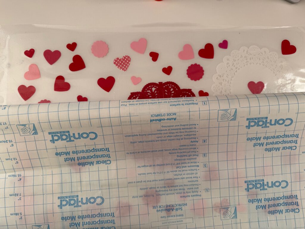 To adhere contact paper to the placemat, start at the top of the placemat and gradually roll out the rest of the contact paper over the rest of the placemat.