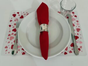 These Valentine placemats are made by gluing paper hearts onto inexpensive plastic placemats.