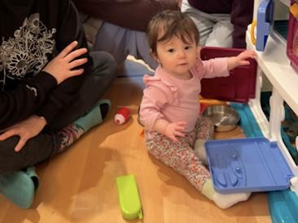 Toddler plays at a kitchen set handed down from another family whose grandkids have grown.