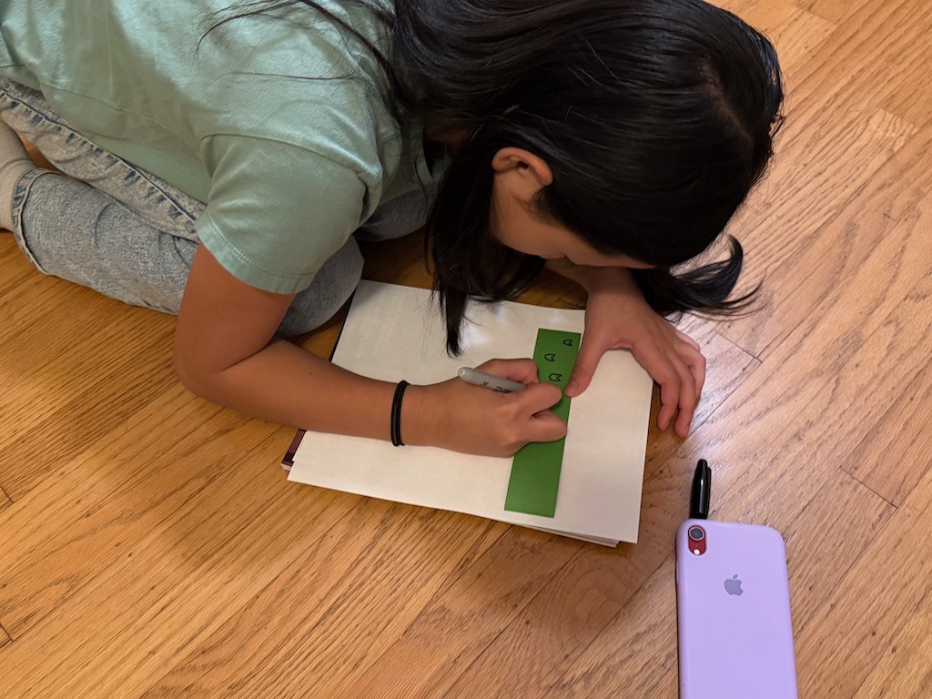 What age is a smartphone appropriate for a child? Child does craftwork with a smartphone at her side for listening to an audiobook.