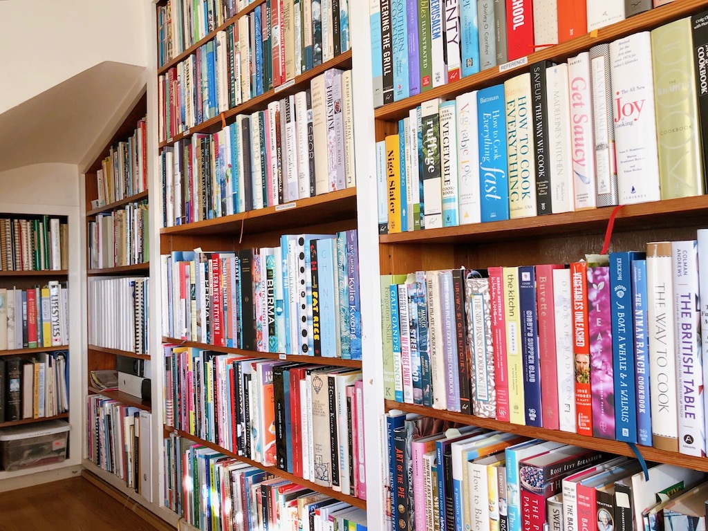 Bookshelves of several hundred cookbooks to be sorted; unused ones to be given away to clean up.