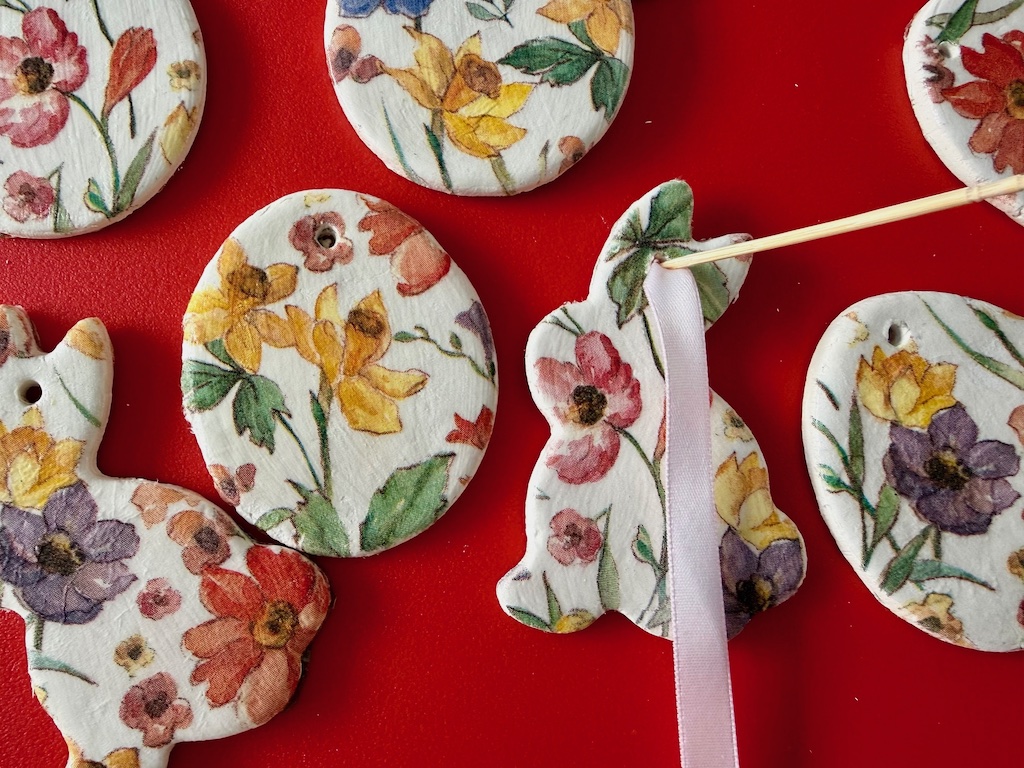 To thread a ribbon through the hole of the Easter ornament, poke a ribbon through the hole with a toothpick.