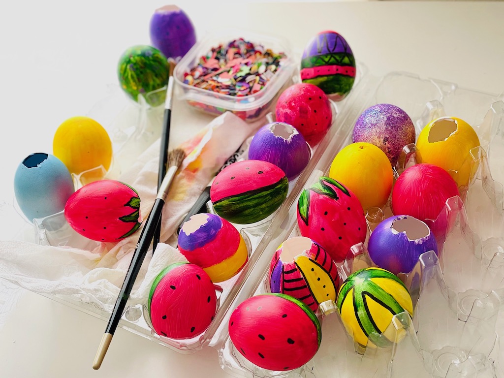 Hollow eggs are colored and decorated, then filled with confetti. The hole is covered with tissue paper and glued in place.