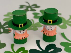 Two leprechauns are made with toilet paper roll, paint, cardboard, and construction paper.