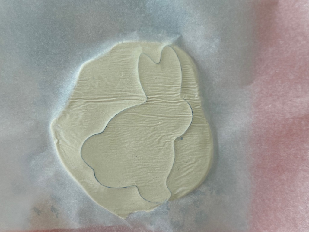 To ensure that the cookie cutter cut all the way through, flip over the layers of napkin, clay, and cookie cutter and trace over the cut lines with a rolling pin or chopstick.