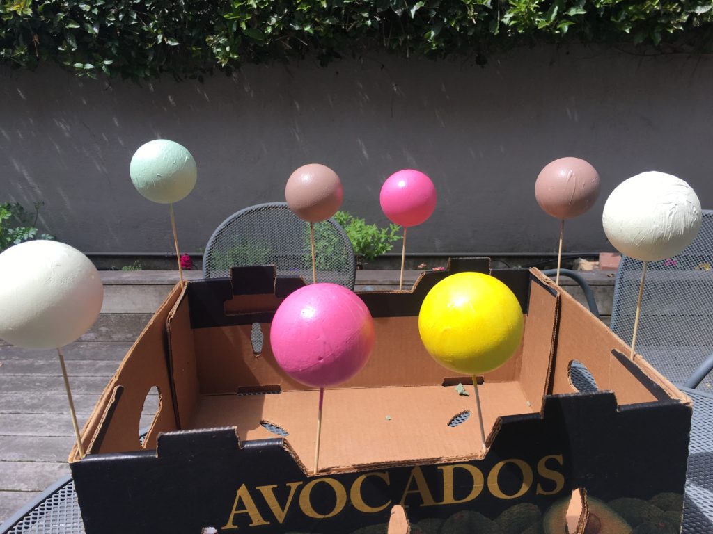 Spear chopsticks into styrofoam balls so they can be painted easily. To dry, shove the other end of the chopstick into the edge of a corrugated box.