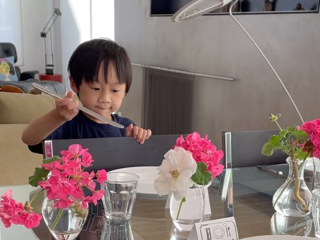 A six-year-old child sets the table for the tradition of a weekly family dinner. 